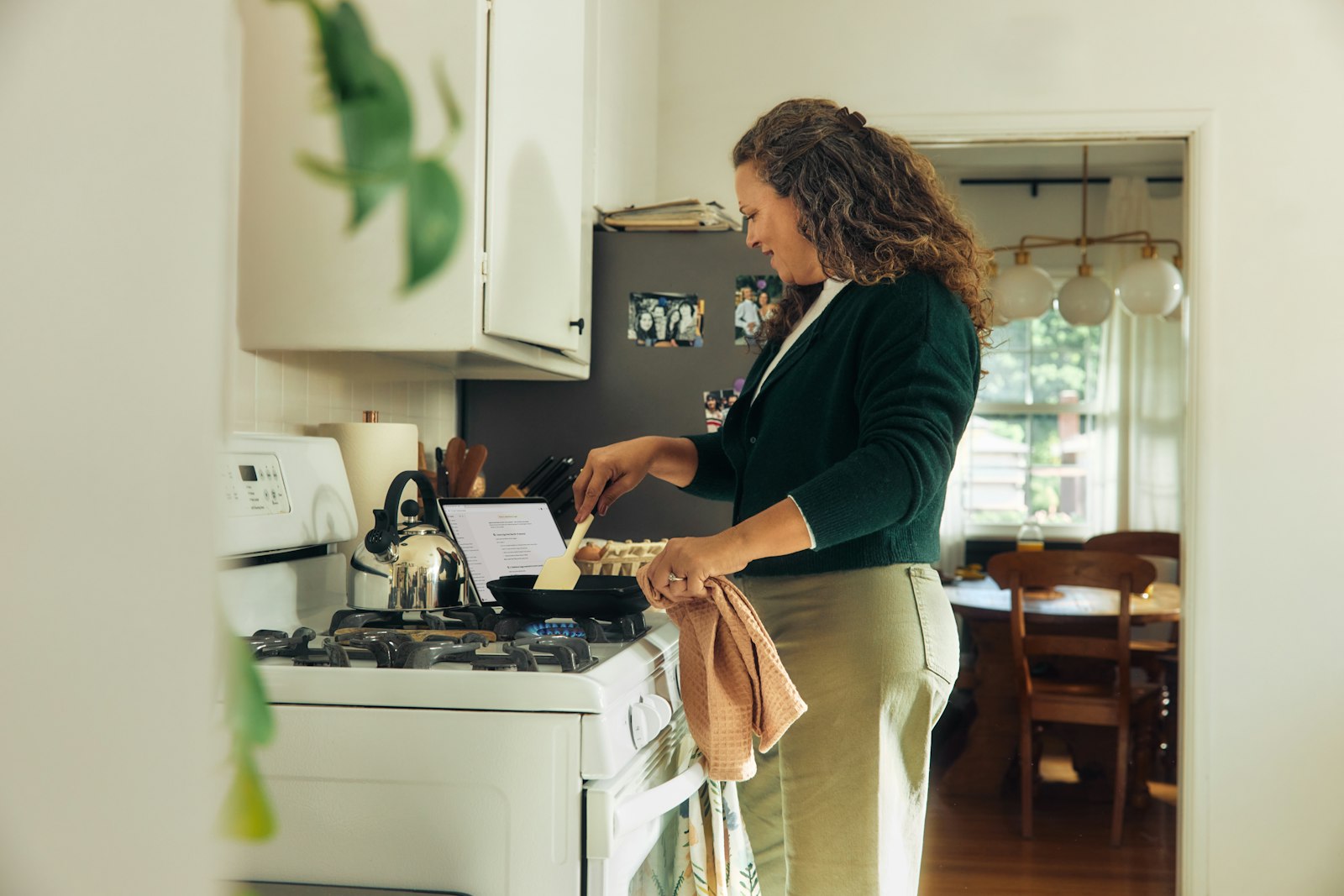 A person following a recipe on a tablet while cooking in the kitchen